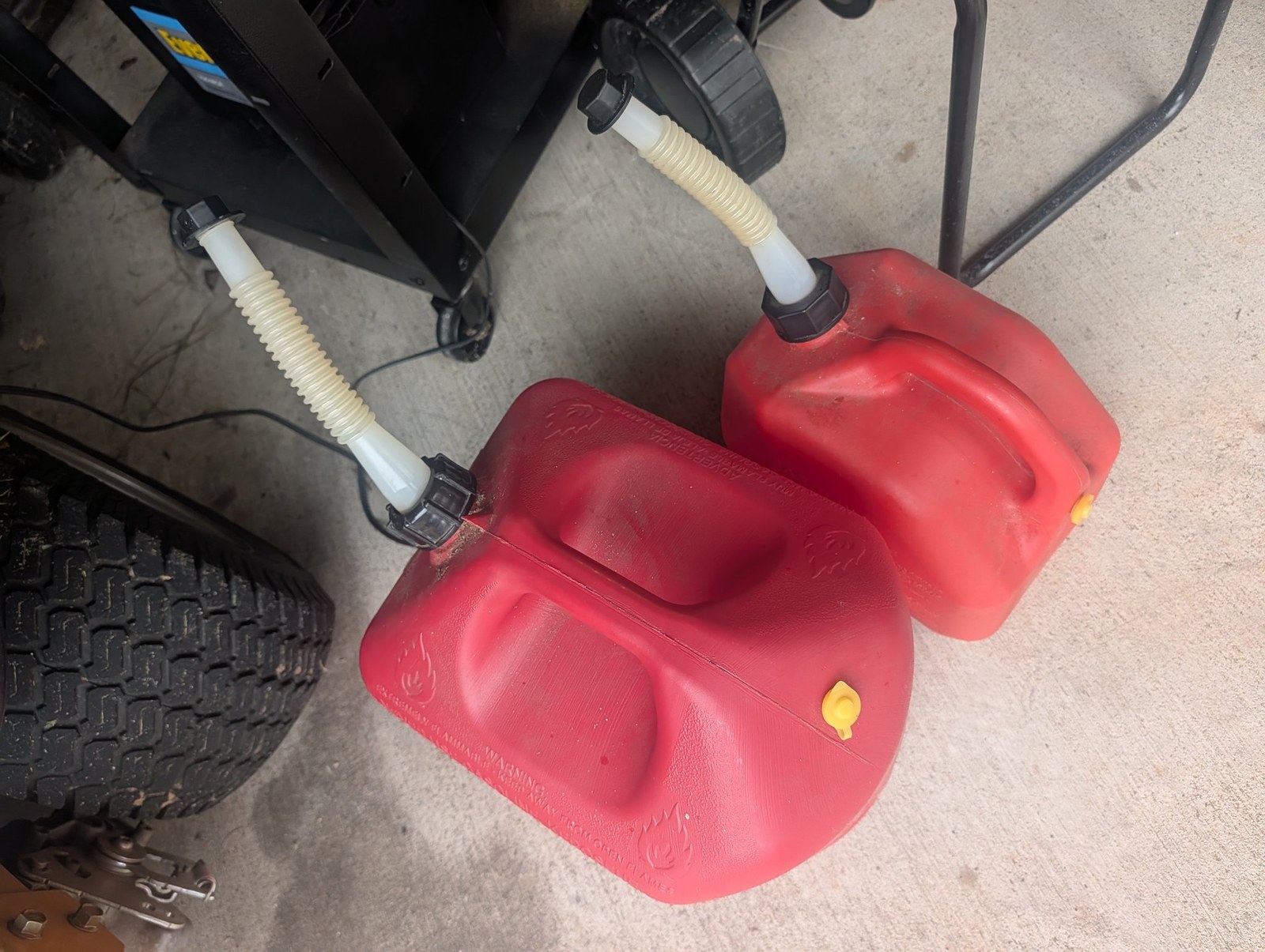 Two filled gas cans on the garage floor ahead of tropical weather