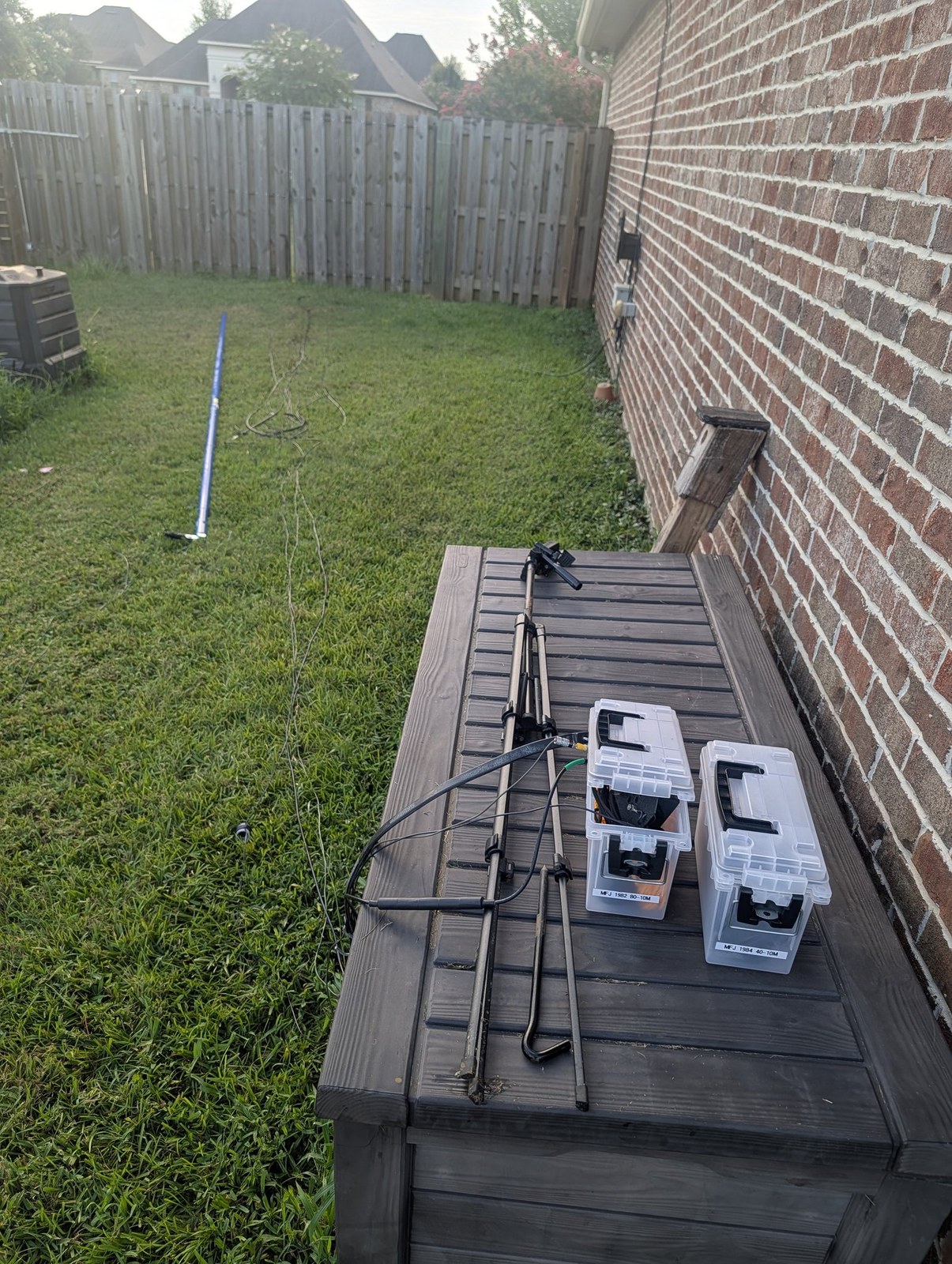 Mast sections, coax and MFJ end-fed transformer cases laid out in the side yard