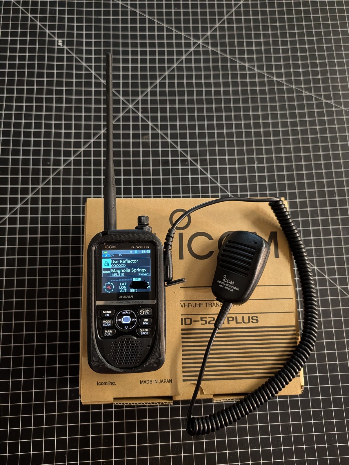 ICOM ID-52A Plus dual-band D-STAR handheld radio with HM-186LS speaker microphone, resting on its original box