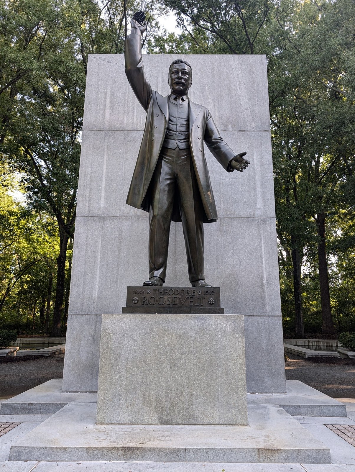 Bronze statue of Theodore Roosevelt at the Theodore Roosevelt Island memorial, surrounded by trees